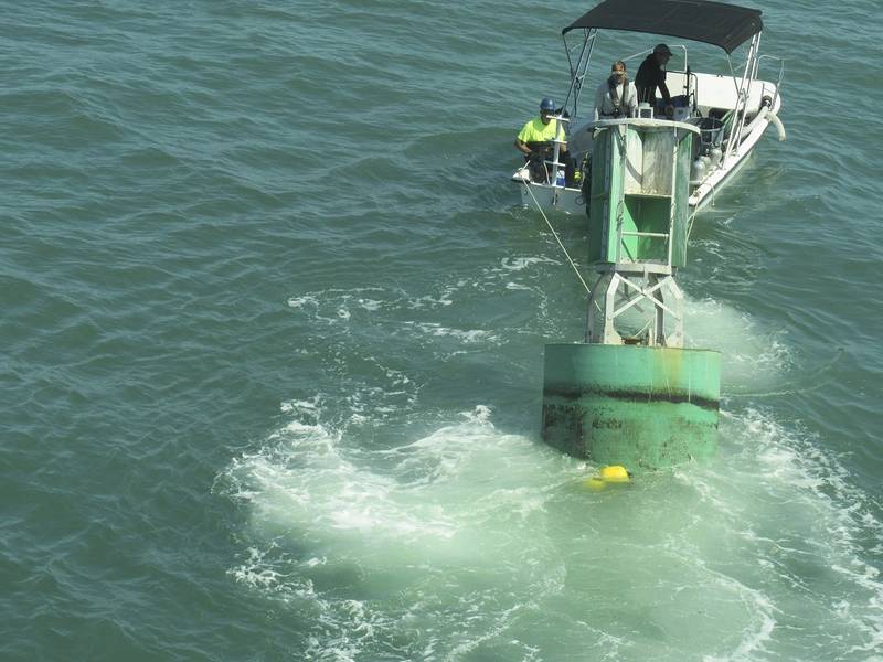 Ein Taucherboot schleppt eine Boje mit angehängter Eco-Mooring-Schnur in Richtung Taucher, die darauf warten, sie an einem der Anker zu befestigen (Foto mit freundlicher Genehmigung der US-Küstenwache)