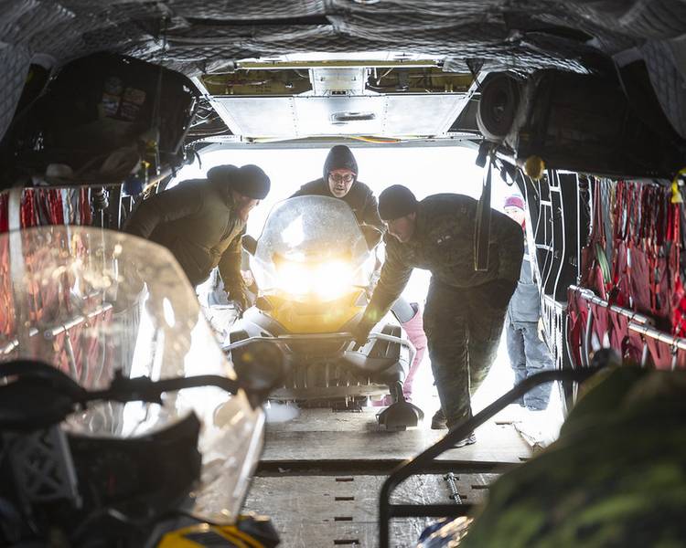 Miembros del 1.er Grupo de Patrulla Ranger Canadiense y el Sargento Andrew Deutsch, de la tripulación del CH-147F Chinook, cargando una motonieve antes del despegue hacia el campamento de la Zona de Aterrizaje de Esquí (SLA) como parte de la Operación NANOOK-NUNALIVUT en Inuvik, Territorios del Noroeste. Crédito: Cabo Jacob Hanlon, Foto de las Fuerzas Canadienses.
