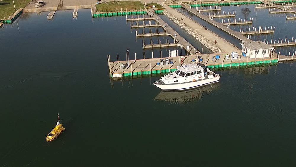 O R / V Storm da NOAA espera que a ASV BEN deixe a marina de Rogers City para iniciar as operações de mapeamento no Lago Huron durante a expedição. (Foto: David Cummins / Alpena Community College)