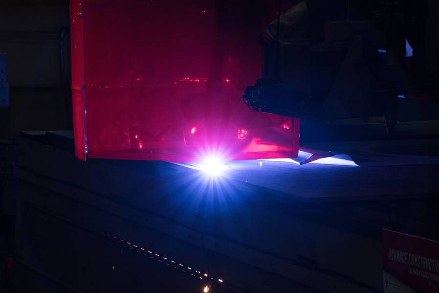 Uma máquina de queima de plasma corta a primeira placa de aço que será usada para construir o submarino de mísseis balísticos Columbia (SSBN 826). Foto de Matt Hildreth / HII