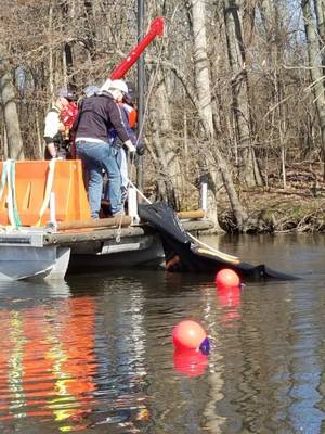 Pesquisadores usam um guincho para recuperar uma seção do sistema de barreiras submersas de petróleo do Rio Kalamazoo, Michigan, quarta-feira, 25 de abril de 2018. Barricadas de plástico preenchidas com areia mantiveram o sistema de barreira no fundo do rio, enquanto bóias de ancoragem marcaram a localização do teste. (Foto cedida pelo Centro de Pesquisa e Desenvolvimento da Guarda Costeira dos EUA)