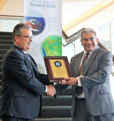 Von links nach rechts: Craig McLean von NOAA präsentiert Edward Saade von Fugro eine Gedenktafel zur offiziellen Anerkennung der Führungsrolle des Unternehmens bei der weltweiten Kartierung der Ozeane (Foto: Fugro)