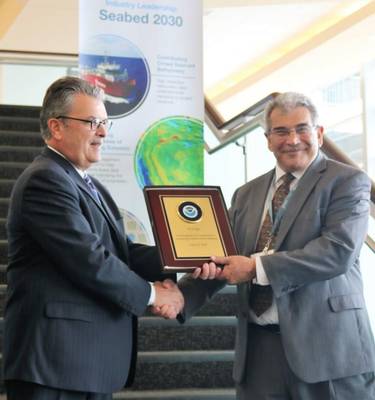 De izquierda a derecha: Craig McLean de NOAA presenta a Edward Saade de Fugro con una placa conmemorativa en reconocimiento formal del liderazgo de la compañía en el avance del mapeo global del océano (Foto: Fugro)