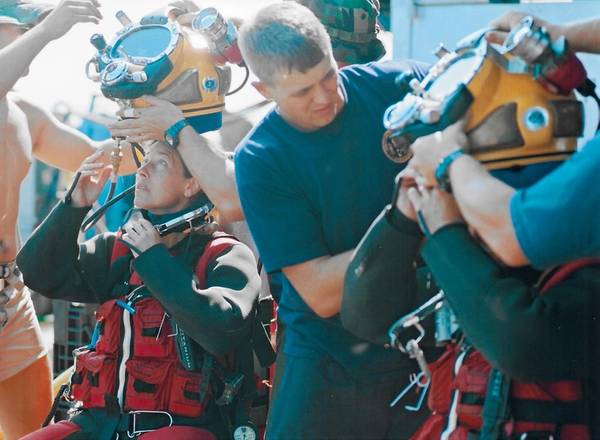El comandante Bobbie Scholley y el capitán Chris Murray en Mk 21 con trajes de agua caliente DUI en preparativos para sumergirse a 240 pies de agua durante la Expedición MONITOR 2001. Foto cortesía de la Marina de los EE. UU./Publicada.
