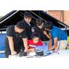 Mirolla Saleb (center) of Bishop Stang High School in North Dartmouth, Massachusetts, drives her team’s remotely operated vehicle (ROV) in a test pool as teammates Alexander Tungkasiri (from left) of The Pennington School in New Jersey, and Rhode Island students, Joseph Vitolo of East Providence High School, Cole Shotwell of North Kingstown High School, and Avi Tripurneni of East Greenwich High School, look on. The ROV competition, held on Aug. 13, 2025, was part of the Naval Undersea Warfare Ce