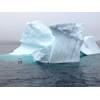 Small experimental unmanned surface craft conducting experiments near an iceberg.