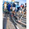 WHOI researcher Alan Gagnon, Marco Coolen (center, in blue safety helmet), and the crew from the Bulgarian research vessel Akademik sample the sediment core that was used for this study. (Photo courtesy Dimitri Dimitrov from the Institute of Oceanology, Bulgarian Academy of Sciences (IO-BAS))
