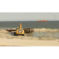 Bulldozers reconstruct the beach and dunes at Long Beach Island, New Jersey, as a dredge ship pumps sand from the Outer Continental Shelf to shore. Photo BOEM