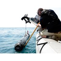 A civilian contractor steadies a M18 Mod 2 Kingfish Unmanned Underwater Vehicle (UUV) as it is lifted with a crane onto the deck of an 11-meter rigid-hull inflatable boat. (U.S. Navy photo by Mass Communication Specialist 2nd Class Blake Midnight/Released)