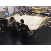 Investigators examine piece of aircraft debris (Photo: ATSB)
