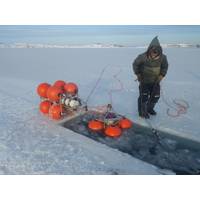 Joey Angnatok preparing ADCP and IPS mooring cages for deployment through the ice. 
 (Photo credit: James Barlett)