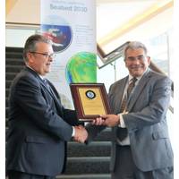 Left to right: Craig McLean of NOAA presents Fugro’s Edward Saade with a commemorative plaque in formal commendation of the company’s leadership in advancing global ocean mapping (Photo: Fugro)