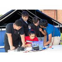 Mirolla Saleb (center) of Bishop Stang High School in North Dartmouth, Massachusetts, drives her team’s remotely operated vehicle (ROV) in a test pool as teammates Alexander Tungkasiri (from left) of The Pennington School in New Jersey, and Rhode Island students, Joseph Vitolo of East Providence High School, Cole Shotwell of North Kingstown High School, and Avi Tripurneni of East Greenwich High School, look on. The ROV competition, held on Aug. 13, 2025, was part of the Naval Undersea Warfare Ce
