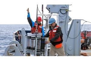Marine chemist Ken Buesseler (right) deploys a sediment trap during a 2018 expedition in the Gulf of Alaska. © Alyson Santoro, Woods Hole Oceanographic Institution
