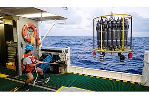A marine technician hauls in the CTD (conductivity, temperature, and depth) rosette on a research cruise in the Sargasso Sea. © Maya Thompson
