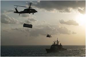 An MH-60S Sea Hawk helicopter, assigned to the "Sea Knights" of Helicopter Sea Combat Squadron (HSC) 22, transports supplies over the guided-missile cruiser USS Gettysburg (CG 64) during a replenishment-at-sea with the aircraft carrier USS Harry S. Truman (CVN 75) in the Arabian Gulf. (U.S. Navy photo by Seaman Karl Anderson)