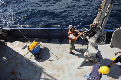 Crew aboard the Office of Naval Research (ONR)-sponsored research vessel (R/V) Melville retrieve a wave buoy during an at-sea demonstration of the Environmental & Ship Motion Forecasting (ESMF) program.