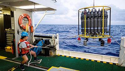 A marine technician hauls in the CTD (conductivity, temperature, and depth) rosette on a research cruise in the Sargasso Sea. © Maya Thompson