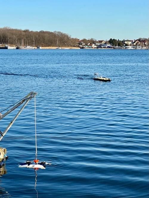 The A.IKANBILIS tehtherless, Hovering Autonomous Underwater Vehicle (HAUV) being launched in the foreground, with the Unmanned Surface Vehicle (USV) Autonomous Surveyor in action in the background (Credit: Subsea Europe Services)