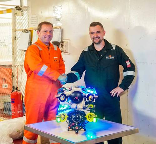 Alexander Bahr, Hydromea COO, and Keiran Hope, ACE COO, shake hands on service partnership with EXRAY wireless ROV in the center. Image courtesy Hydromea