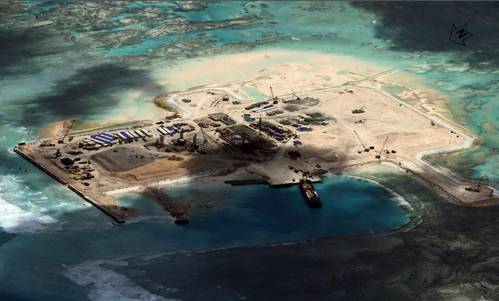 The artificial island at Cuarteron Reef, one of many being developed by China in the South China Sea, saw most of its construction and dredging during the summer of 2014. Construction of buildings and facilities continues today.  (Photo: CSIS Asia Maritime Transparency Initiative)