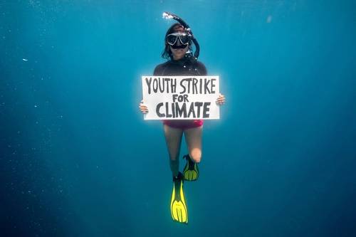 Climate activist Shaama Sandooyea holds a placard reading 'Youth Strike For Climate' in support of the climate strike movement. During an underwater protest in the Saya de Malha bank in the Indian Ocean. (© Tommy Trenchard / Greenpeace)