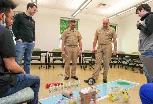 DAHLGREN, Va. – VADM William Galinis watches as NSWC Dahlgren Division Commanding Officer Capt. Philip “Phil” Mlynarski stops Bridging Communities Governor’s School’s wayward robot as they meet with the students prior to competition at Innovation Challenge @Dahlgren. (U.S. Navy photo -Released)