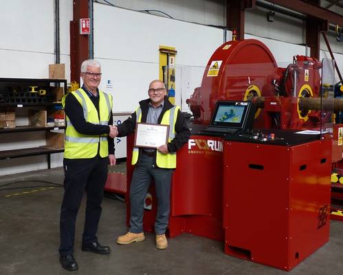 David Neill of TAM International (left) receives a plaque from George Hendry, business development manager for Forum AMC, recognising the purchase of the 350th RT torque machine. (Photo: TAM)