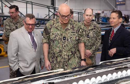 Dennis Boyer (from left), deputy commander, Undersea Warfighting Development Center (UWDC), UWDC Commander Rear Adm. Michael R. Van Poots and Capt. Todd Moore, UWDC chief of staff, listen as Tony Paolero, head of the Naval Undersea Warfare Center Division Newport’s Sensors and Arrays Division, explains the mission of the Naval Array Technical Support Center during a tour at Division Newport on March 31, 2025. Credit: U.S. Navy/Nick Froment)