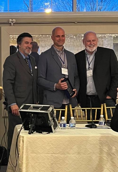  Greensea’s CEO Ben Kinnaman, center, with the "Rising Tide" award. Image courtesy Greensea