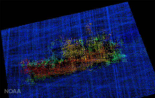 A 3-D image from NOAA Ship Fairweather multi-beam sonar. The profile of the F/V Destination is clearly visible, including the bulbous bow to the right, the forward house and mast, equipment (likely crab pots) stacked amidships, the deck crane aft, and the skeg and rudder. (Image: NOAA)