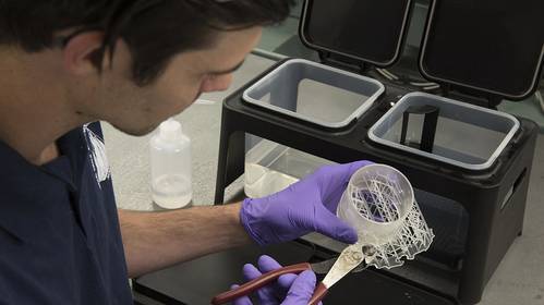 WHOI machinist and resident facilitator D.C. Collasius finishes a part he produced using a 3D resin printer in the new DunkWorks rapid protyping facility. (Photo by Tom Kleindinst, © Woods Hole Oceanographic Institution)