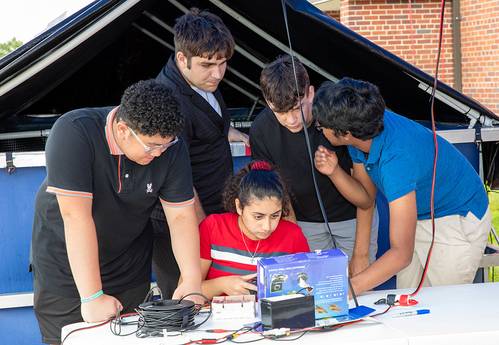 Mirolla Saleb (center) of Bishop Stang High School in North Dartmouth, Massachusetts, drives her team’s remotely operated vehicle (ROV) in a test pool as teammates Alexander Tungkasiri (from left) of The Pennington School in New Jersey, and Rhode Island students, Joseph Vitolo of East Providence High School, Cole Shotwell of North Kingstown High School, and Avi Tripurneni of East Greenwich High School, look on. The ROV competition, held on Aug. 13, 2025, was part of the Naval Undersea Warfare Ce