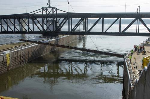 Personnel from the U.S. Army Engineer Research and Development Center and U.S. Geological Survey watch as a 350-ton crane lowers the 105-foot-long weldment, or underwater acoustic deterrent system, into the lock approach of Lock 19 near Keokuk, Iowa, Feb. 3, 2021. Laboratory-tested sounds that proved to be irritating to invasive Asian carp will be broadcast underwater from the weldment as part of a study to evaluate fish behavior. (U.S. Army Corps of Engineers photo)