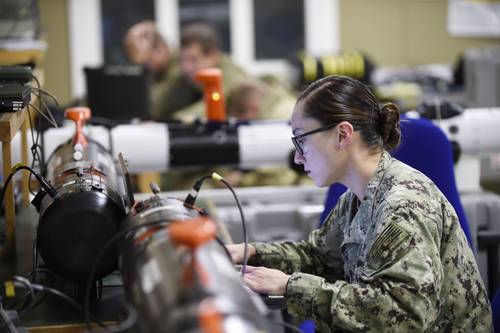 Petty Officer 2nd Class Tammy Helm from the Naval Oceanography Operations Command programs a REMUS 100 unmanned underwater vehicle prior to a mission as part of the first-ever Unmanned Warrior. (U.S. Navy photo by John F. Williams)