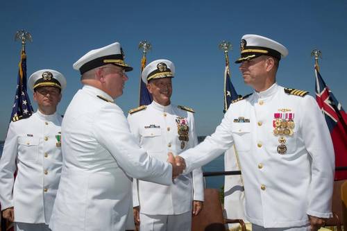 Rear Adm. Michael Jabaley (second from left) shakes hands with Rear Adm. (select) Moises DelToro (right) as they pass command of the Naval Undersea Warfare Center from Jabaley to DelToro.  Looking on are Vice Adm. William Hilarides, commander of the Naval Sea Systems Command (second from right) and Lieut. Philip Carson, Naval Station Newport chaplain (left).