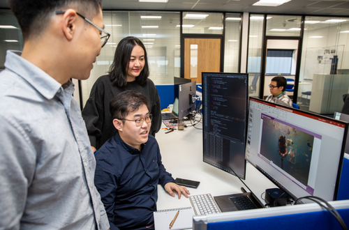 Researchers huddle around a computer at the National Subsea Centre. Credit: RGU