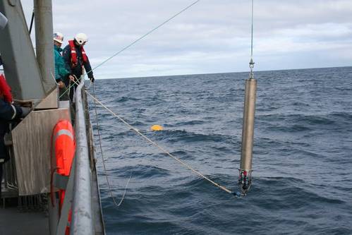 Researchers lowering a hydrophone – a device for recording sound underwater – into the Atlantic Ocean. Dave Mellinger/Oregon State University, CC BY-SA