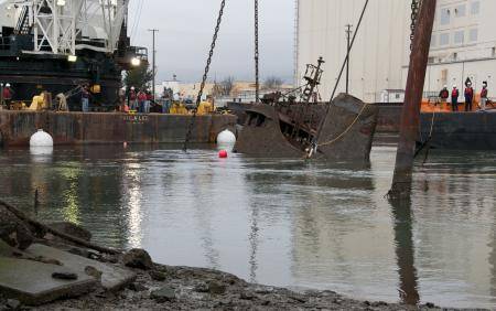 The tug Respect is hauled to the surface of the Oakland Estuary Wednesday, Dec. 18, 2013. The tug, which sank at its moorings in 2007, will be transported to a nearby yard for scrapping. Coast Guard photo by Thomas McKenzie
