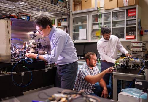 Sandia National Laboratories scientist Jongmin Lee, left, prepares a rubidium cold-atom cell for an atom interferometry experiment while scientists Ashok Kodigala, right, and Michael Gehl initialize the controls for a packaged single-sideband modulator chip. (Photo by Craig Fritz)