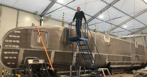 Ben Simpson, SEA-KIT CEO, alongside the 18m XL-class USV hull at the company's production facility in Tollesbury, Essex, UK (Photo credit SEA-KIT International)