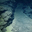 During the 2025 Deep-sea Habitats of the Cook Islands expedition on Exploration Vessel Nautilus the team surveyed various seascapes to better understand seabed environments, and natural and mineral resources in the region. In this image, polymetallic nodules rest on sediment accumulated in a depression between rounded pillows and extended lobate lava flows, which are evidence of ancient volcanoes. (Image credit: Courtesy of Ocean Exploration Trust)
