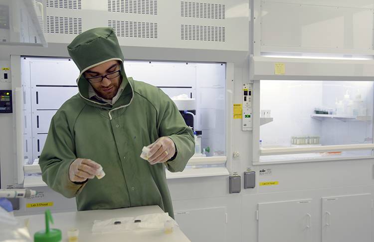Adam Sarafian, lead author of the paper and a MIT/WHOI Joint Program student in the WHOI Geology and Geophysics Department, preps samples in Sune Nielsen's NIRVANA clean lab to remove all contamination from the surface prior to analysis. (Photo by Jayne Doucette, WHOI)