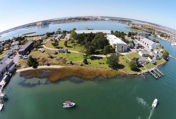 Aerial view of Pivers Island Living Shoreline, constructed from salt marsh plants and submerged oyster reef. The marsh was planted in 2000, and has successfully prevented erosion of the lawn behind the marsh. The NOAA Beaufort Lab buildings are behind the Living Shoreline. (Credit: NOAA)