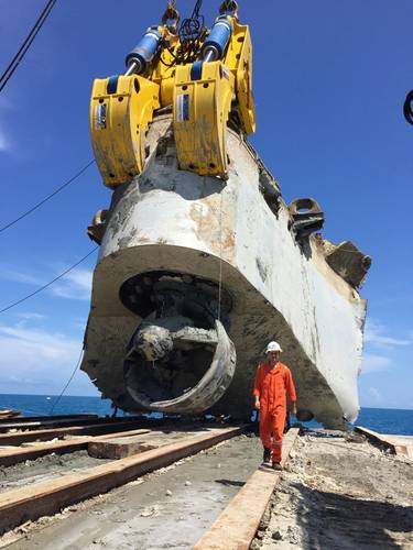 Ardent naval architect Roland De Marco walks in front of the bow piece of the Troll Solution after the salvage team cut and lifted it from the seabed. (Photo: Ardent)