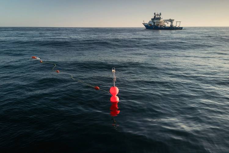 The bright floats of the in-situ 'Cocktail' incubator (Chamber Oxygen Collector Kit Tracer Analyser Insitu Logger) can be seen on the surface of the ocean. Beneath, a robotic system made from glass and titanium called the Submersible Incubation Device (SID) is suspended in the water column. Two SIDs are attached and mounted on this drifting mooring, floating in the Ocean for 24 hours per deployment. The automated system will act like giant glass syringes, pulling water into four chambers. Tracer