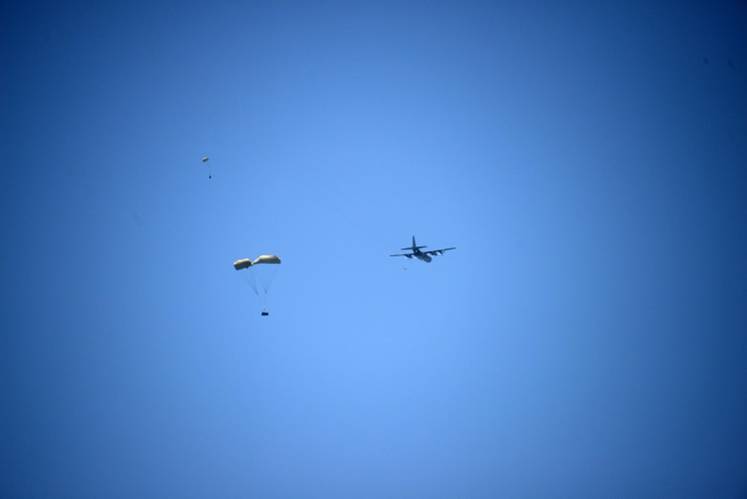 The bundled CRRCs containing the SeaBotix vLBV and an AUV are dropped from the C-130.