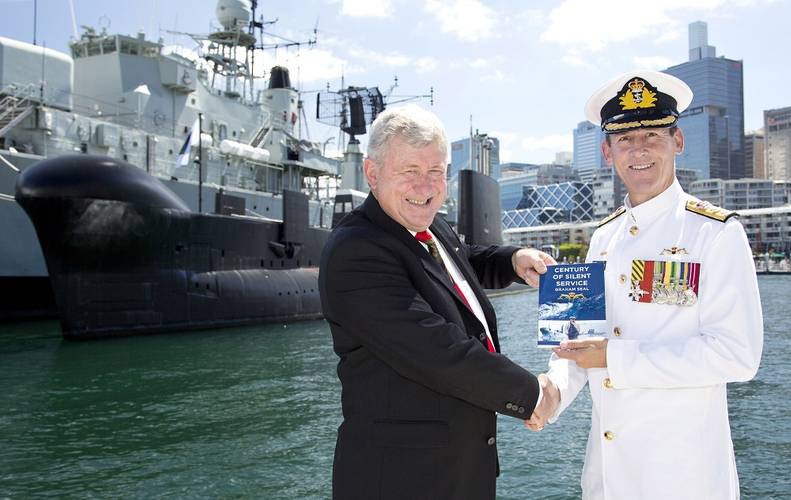 Commodore Peter Scott, CSC, RAN is handed a copy of the book "Century of Silent Service" from one of the authors, Mr Lloyd Blake. (Photo: Tom Gibson)