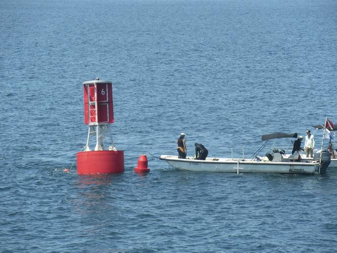 Divers prepare to go underwater for the fastening of the mooring line to its anchor (Photo courtesy of the U.S. Coast Guard)