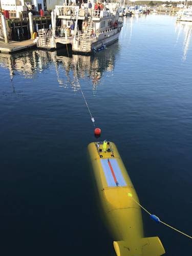 During the 2015 mission to survey the ex-USS Independence CVL 22, the Office of National Marine Sanctuaries' research vessel Fulmar served as the escort boat for Boeing’s AUV Echo Ranger. The 67-foot aluminum catamaran research vessel’s crew is preparing to tow Echo Ranger to sea. (Credit: Robert V. Schwemmer, NOAA)